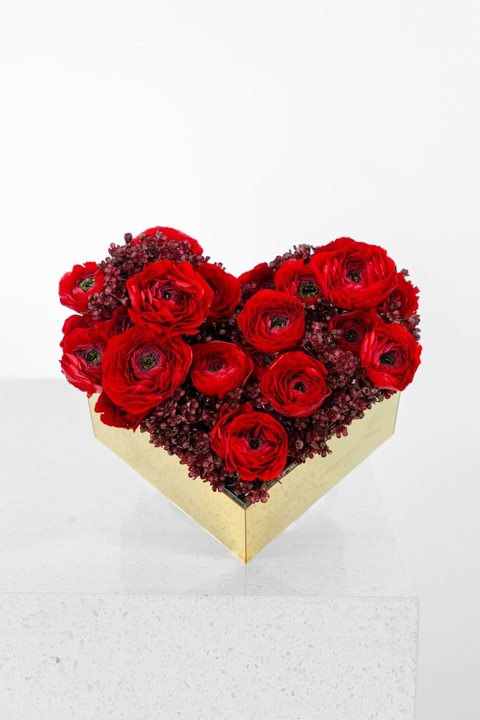 Mix of red ranunculus with wax flower in a mini heart shaped box