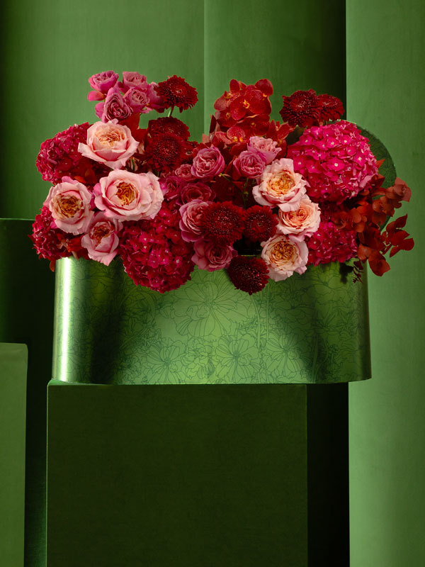 Mix of red flowers with ranunculus, vanda and roses in a Bliss Oval Box