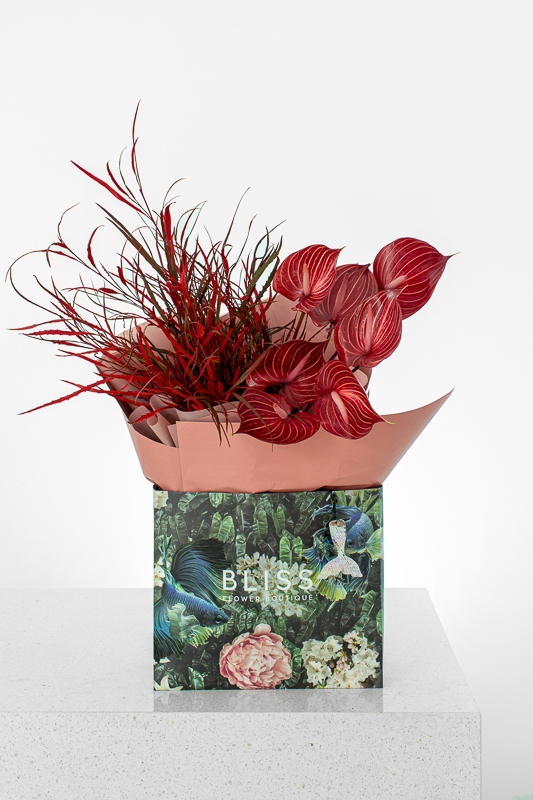 Send red anthurium with red leaves in a Bliss bouquet